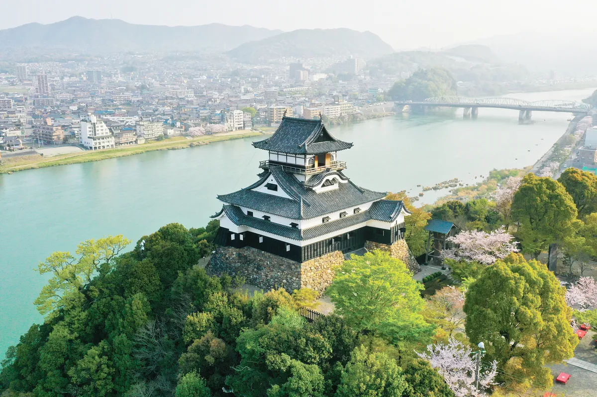 Aerial drone view of Inuyama Castle perched on a hill above the Kiso River